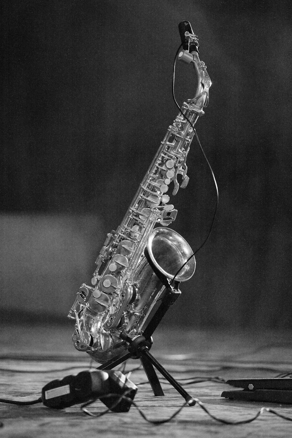 grayscale photo of saxophone on floor