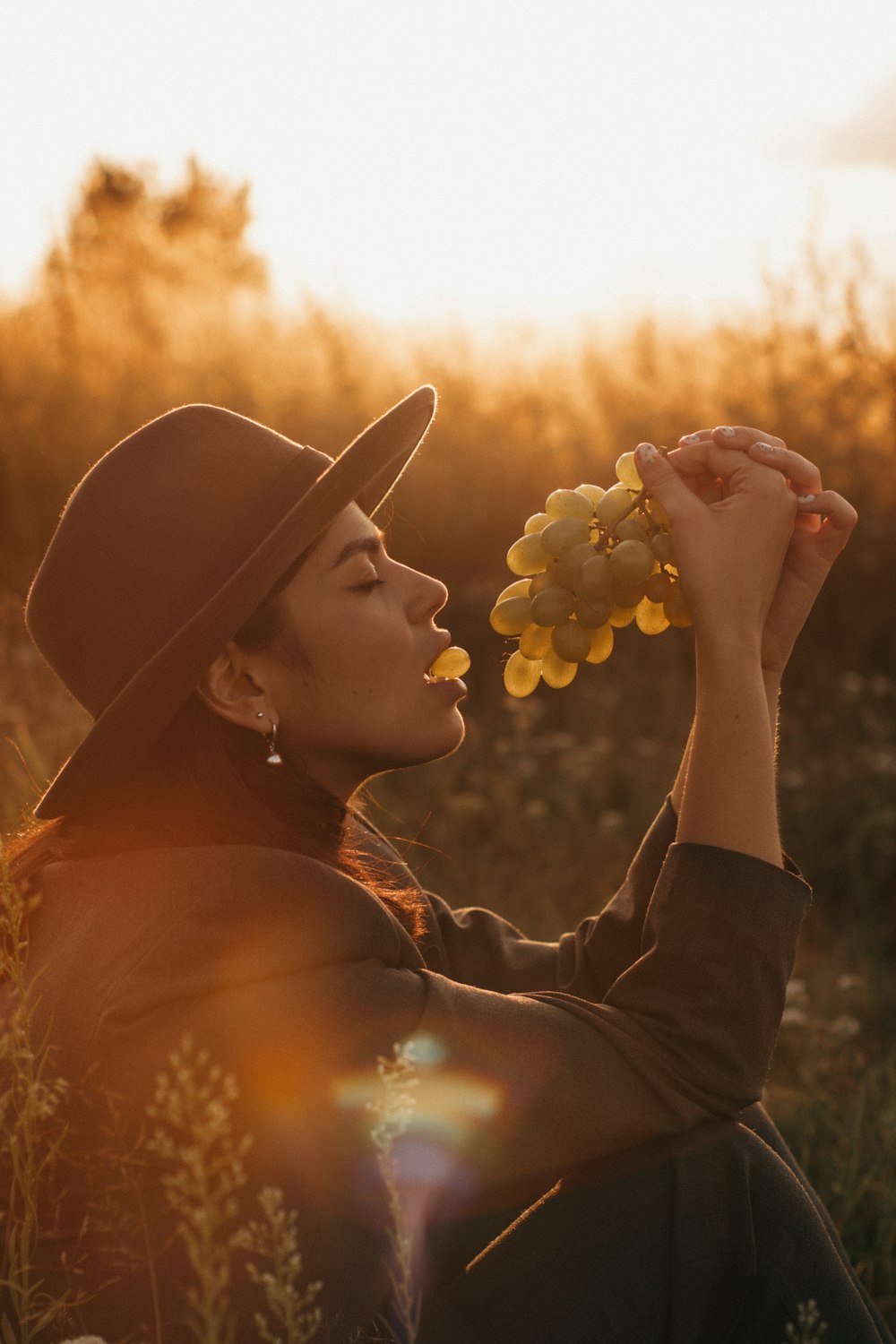 woman in black hat holding white flowers