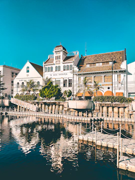 white and brown concrete building beside body of water during daytime