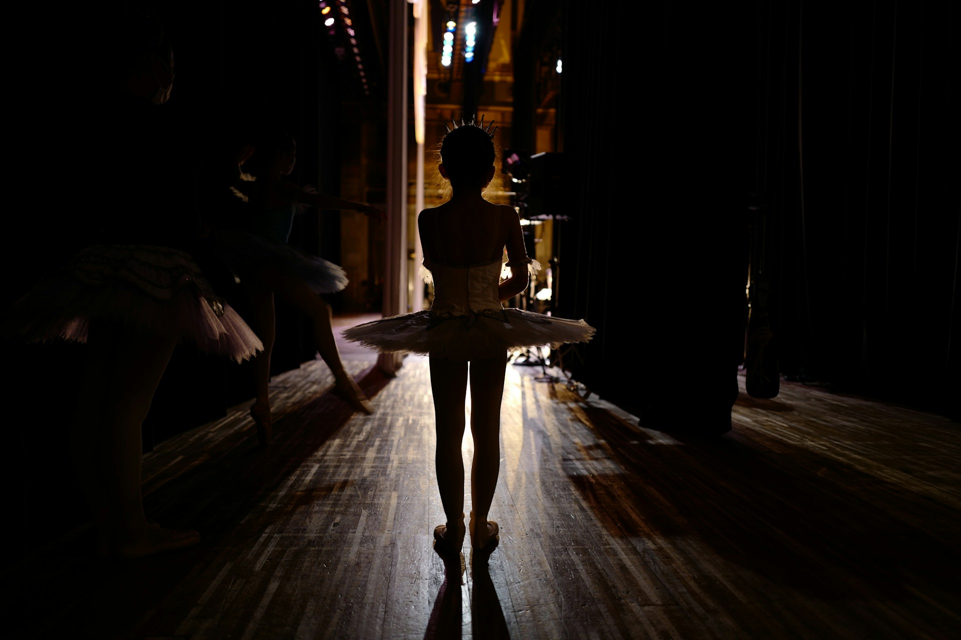 woman in white dress standing on brown wooden floor