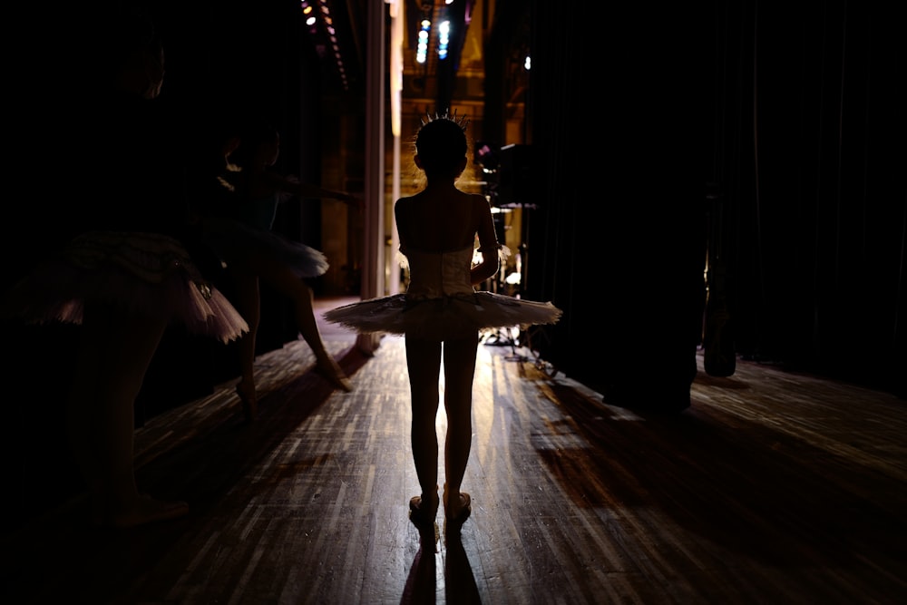 woman in white dress standing on brown wooden floor