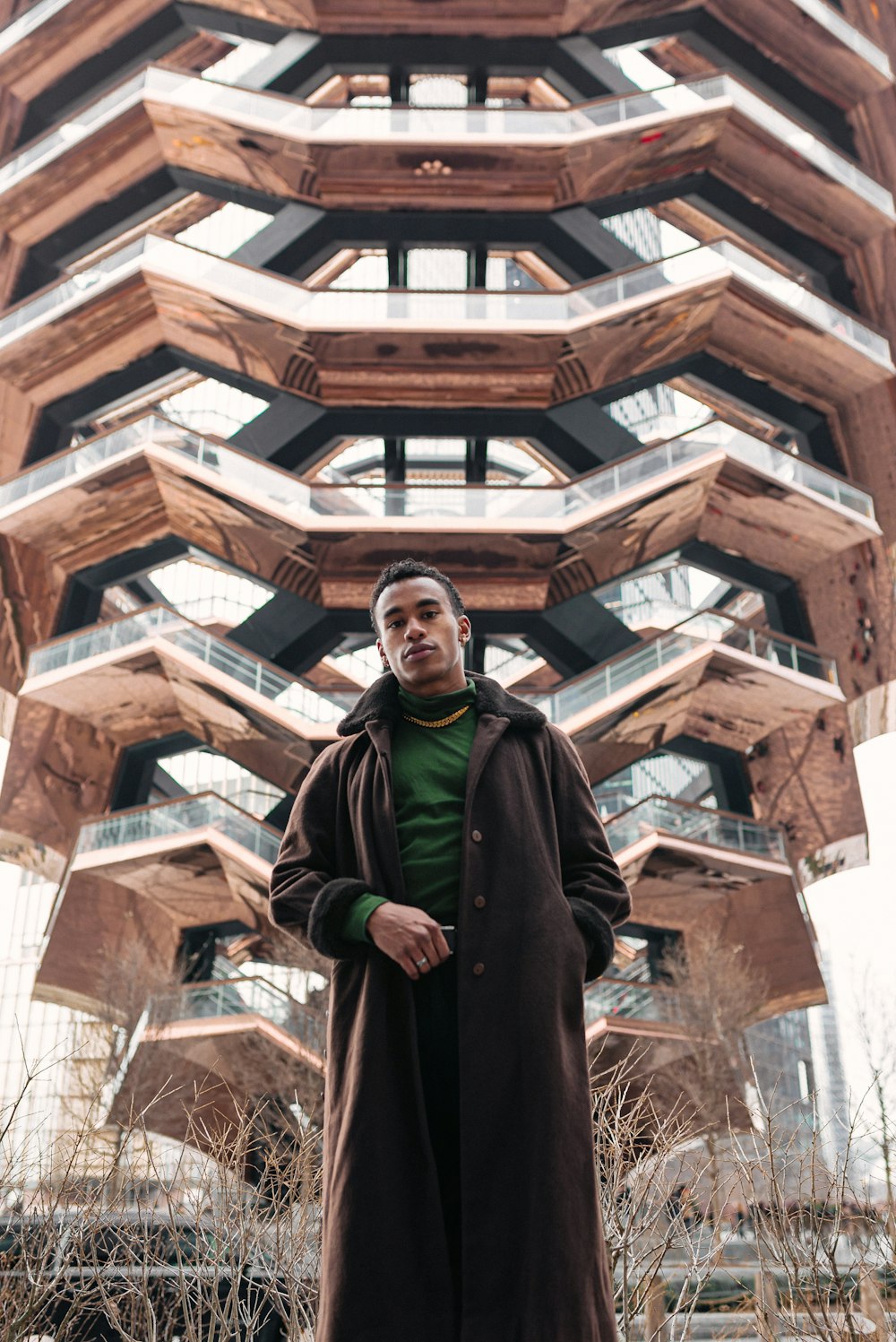 man in black coat standing near brown concrete building