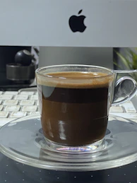 Close-up of hands typing on a keyboard with a subtle gold-accented coffee cup nearby, symbolizing focused work.