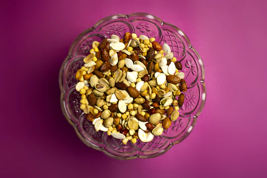 A colorful assortment of almonds, cashews, walnuts, and pumpkin seeds neatly arranged in wooden bowls.