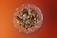 Close-up of a hand holding a glass jar filled with assorted nuts and seeds.