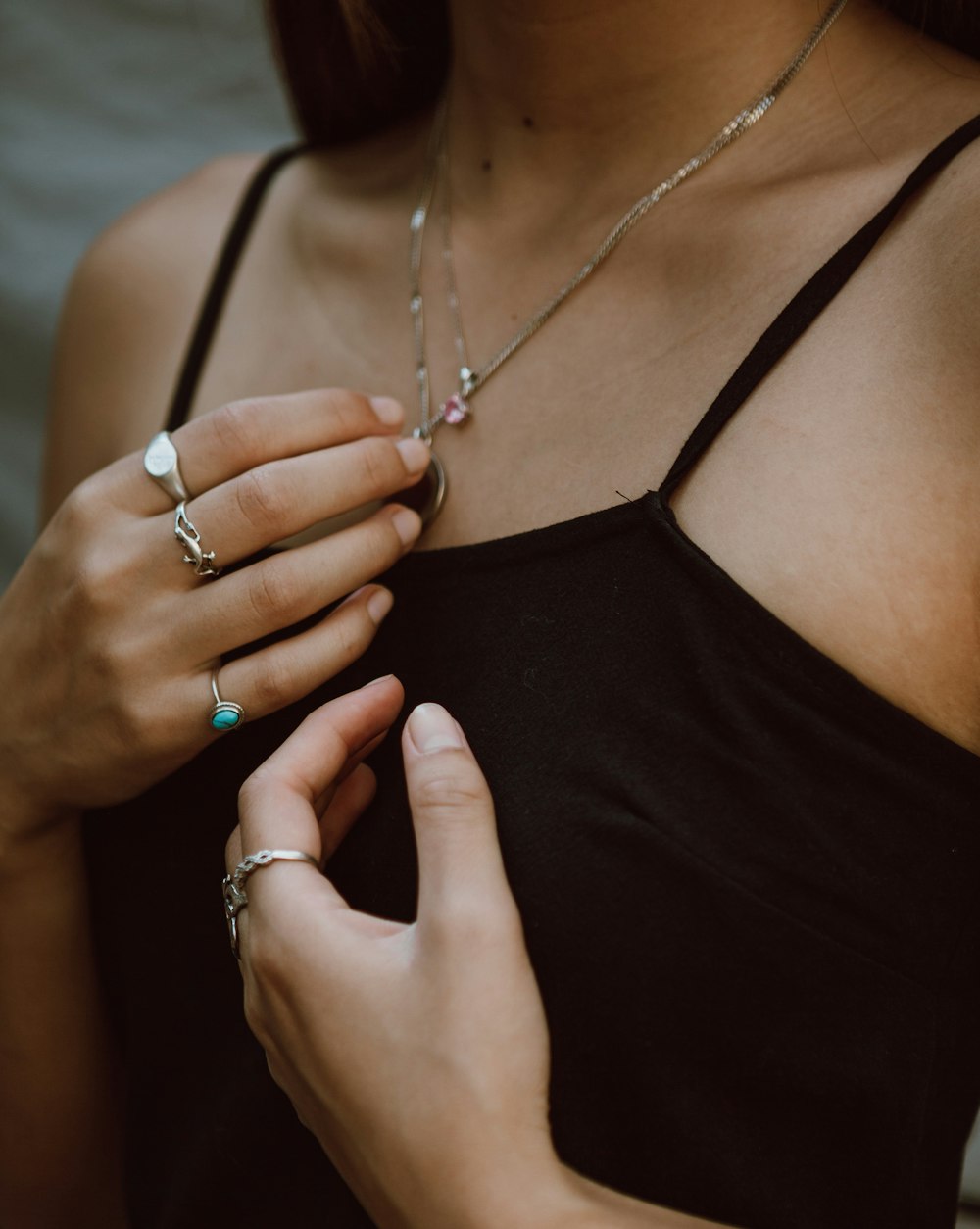 woman in black spaghetti strap top wearing silver necklace