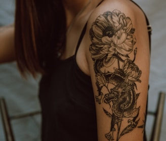 woman with black and brown floral tattoo on her back