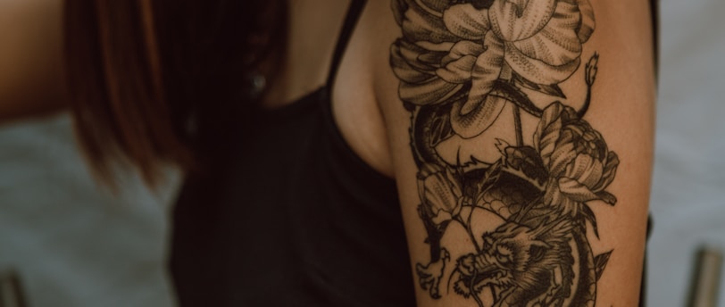 woman with black and brown floral tattoo on her back