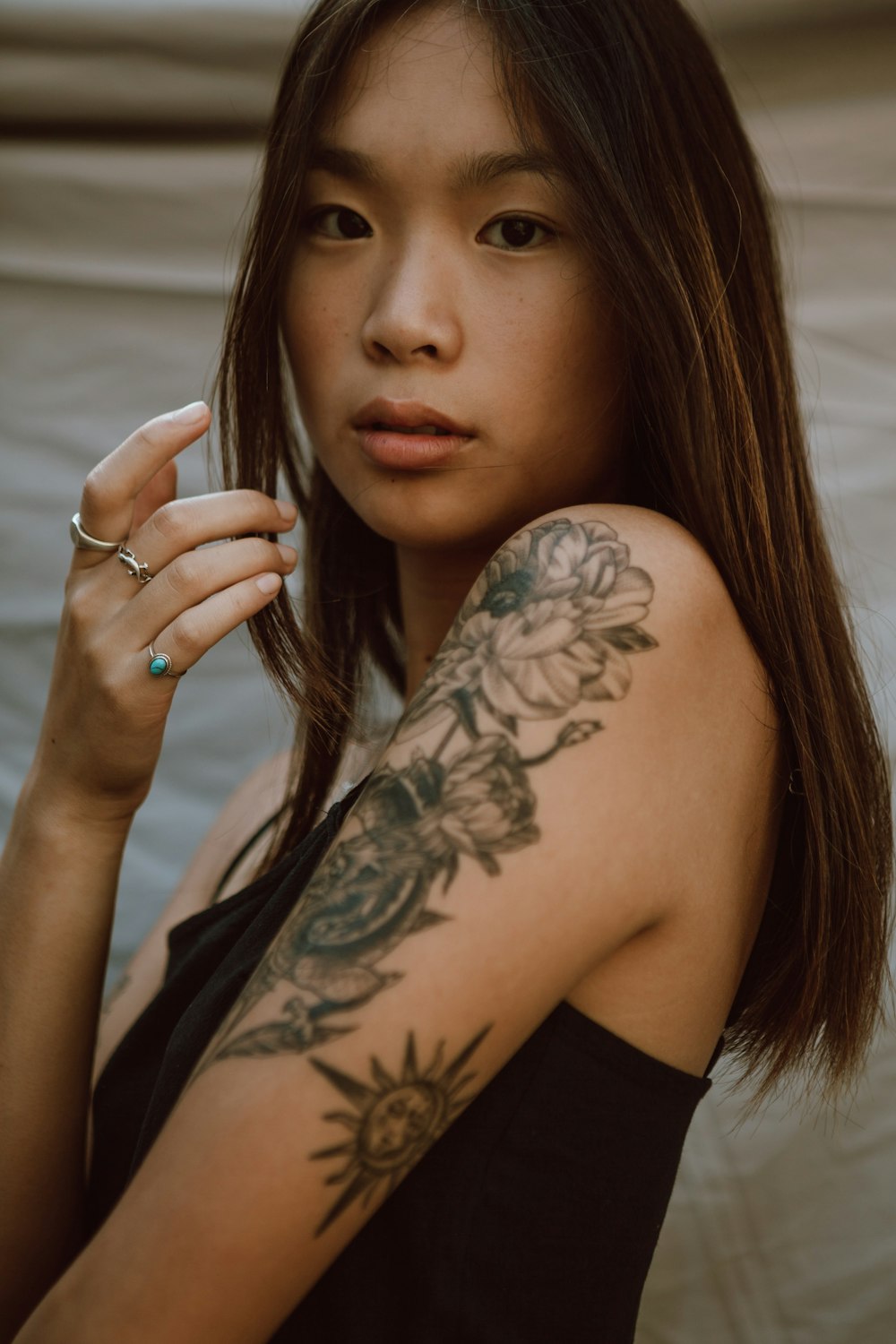 woman with black floral tattoo on her left arm