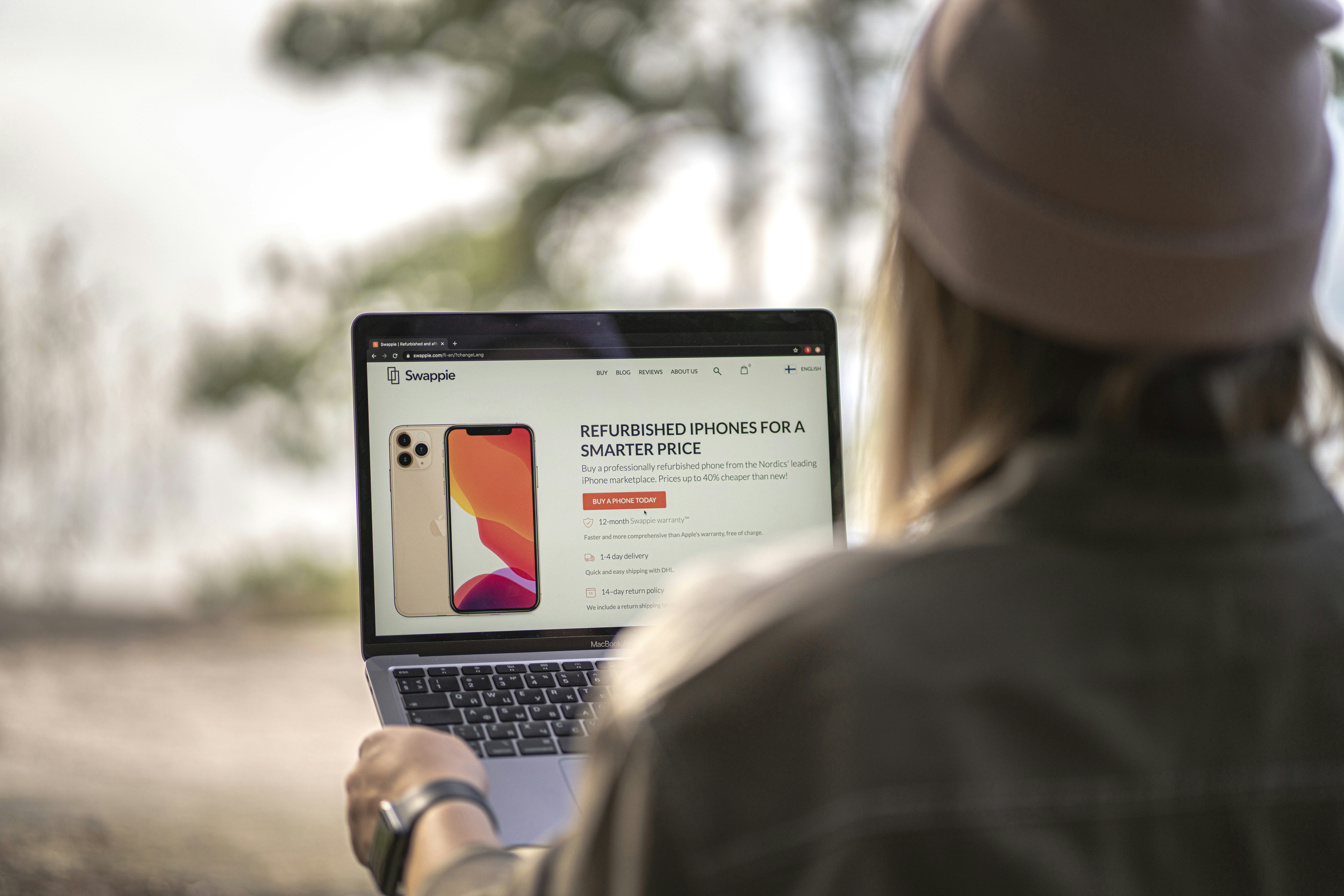 Wanita berjaket hitam menggunakan MacBook Pro