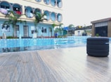 Swimming pool area with smart irrigation and ambient music speakers.