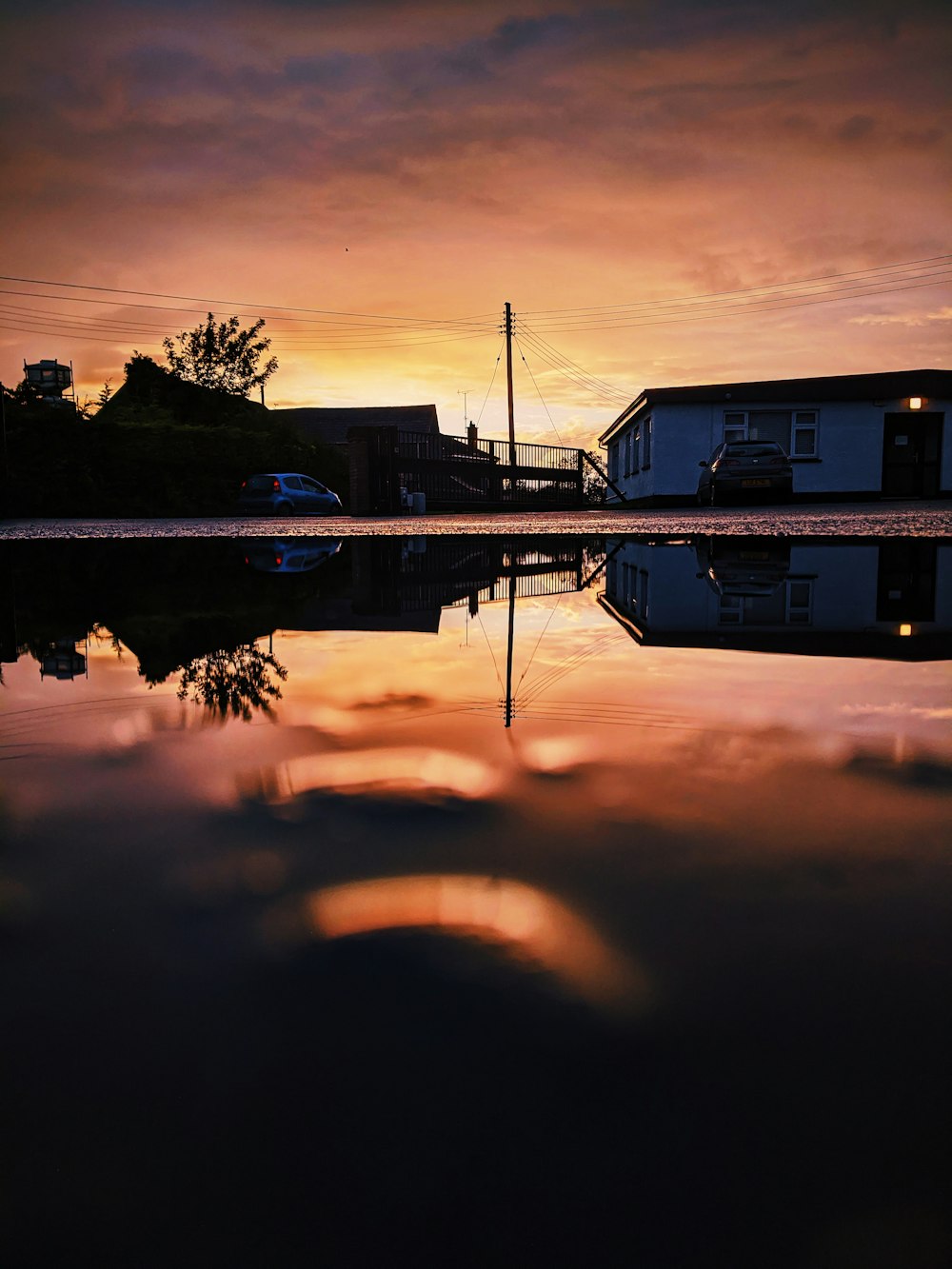 white and brown house near body of water during sunset