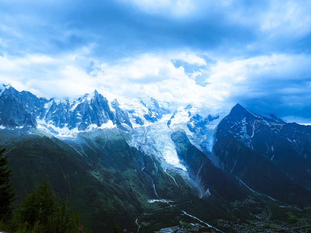 snow covered mountains under cloudy sky during daytime