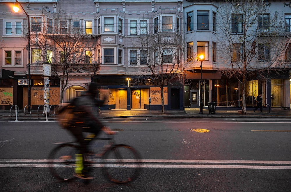 man in black jacket riding bicycle on road during daytime