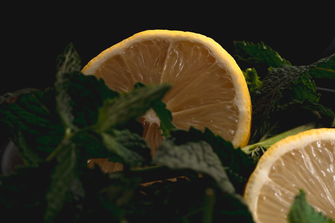 sliced orange fruit on green leaves