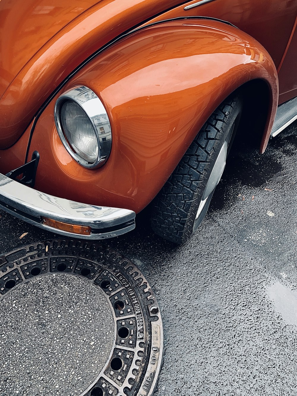 Voiture orange sur route asphaltée grise