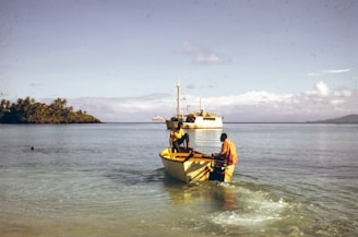 man in yellow shirt riding on yellow and white boat on sea during daytime