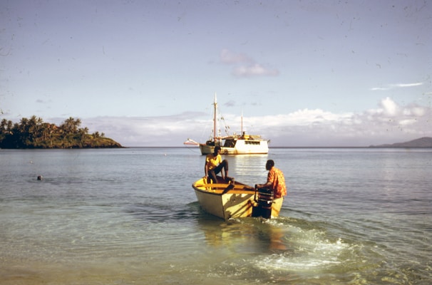man in yellow shirt riding on yellow and white boat on sea during daytime