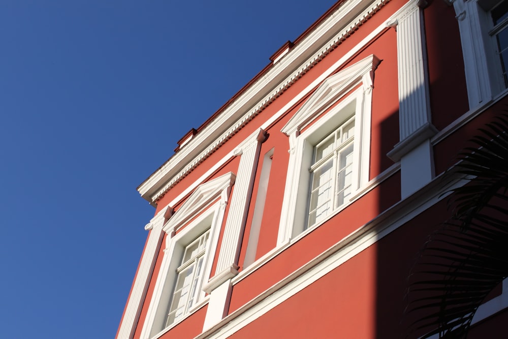 Edificio de hormigón blanco y rojo bajo el cielo azul durante el día