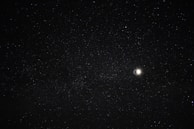 A serene night sky filled with stars and a crescent moon casting a gentle light over mystical tools.