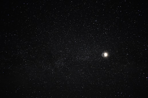 A serene night sky filled with twinkling stars and a glowing crescent moon, evoking a sense of cosmic wonder.