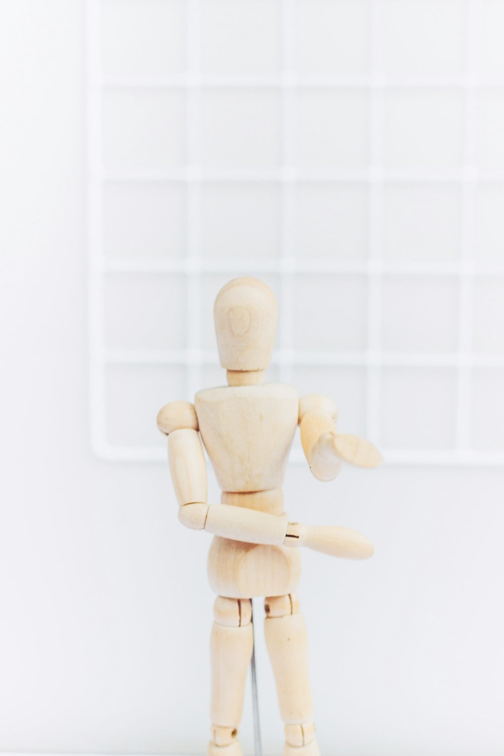Figurine humaine en bois brun sur fond blanc
