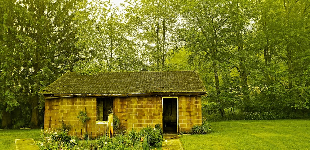 casa de tijolo marrom cercada por árvores verdes durante o dia