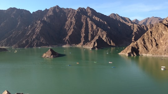 brown rock formation on green water in Hatta - Dubai - United Arab Emirates United Arab Emirates