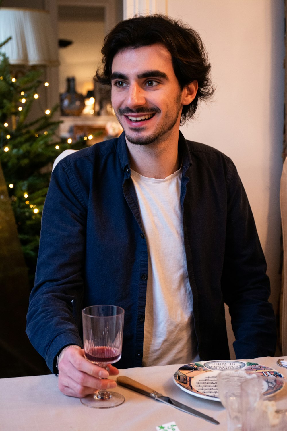 man in blue dress shirt and black blazer holding drinking glass