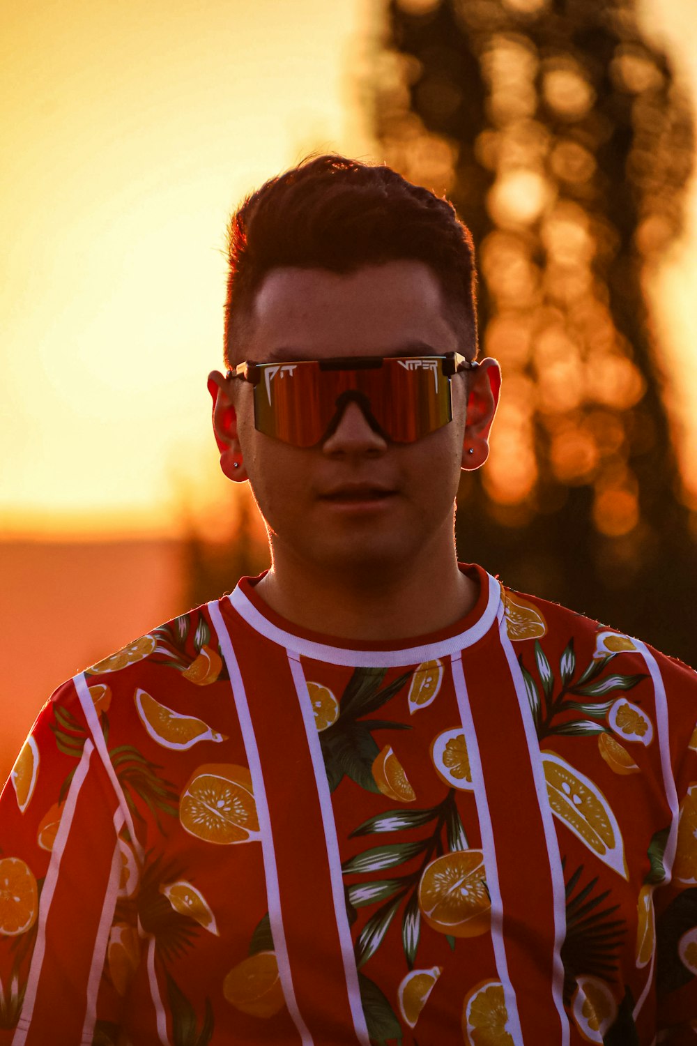 man in red white and yellow floral crew neck shirt wearing black sunglasses