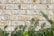 Close-up of detailed brickwork forming a charming garden wall surrounded by greenery.