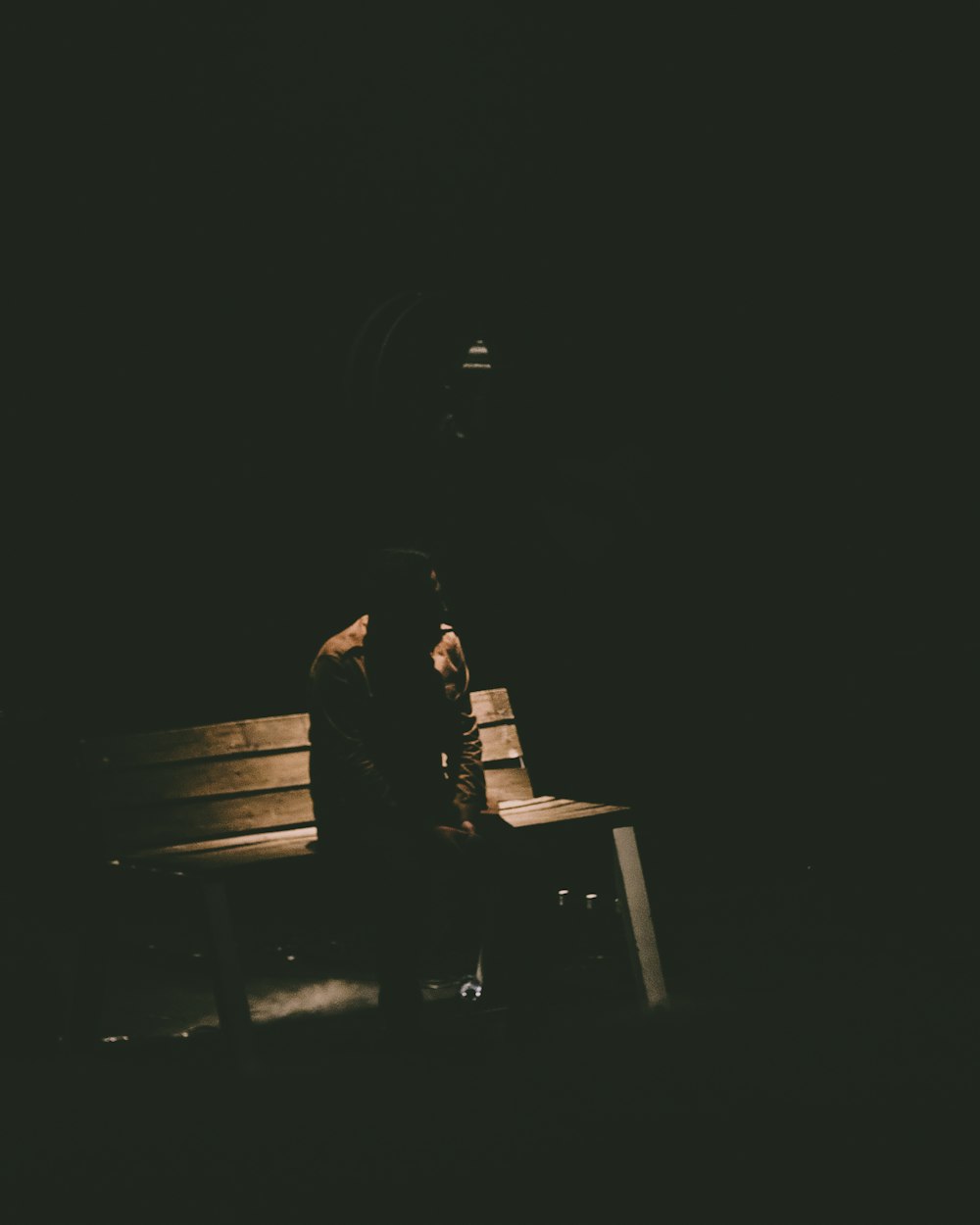 어두운 방에서 벤치에 앉아있는 사람