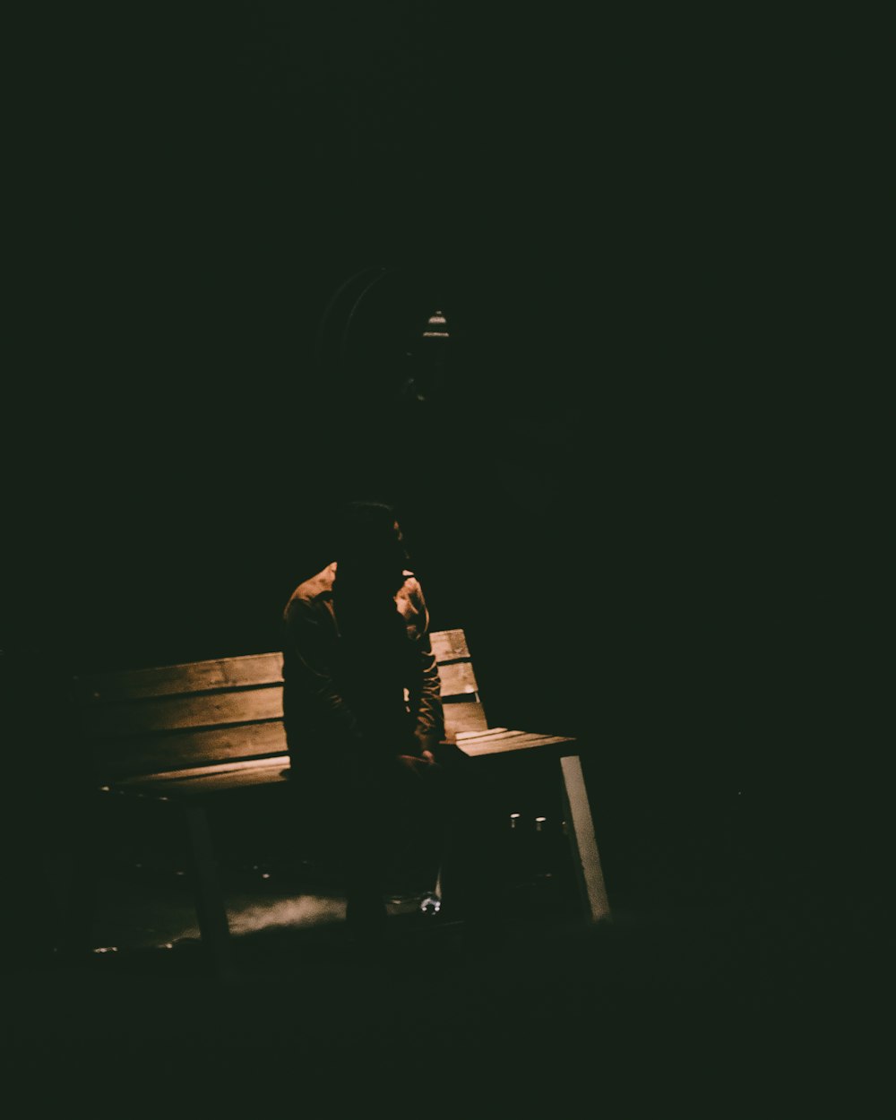 person sitting on bench in dark room