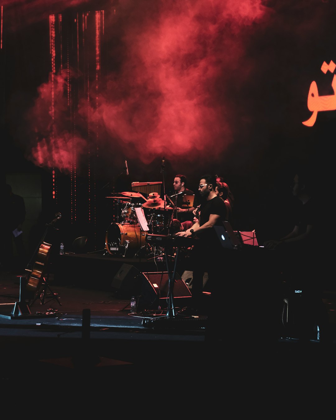 band performing on stage with red lights