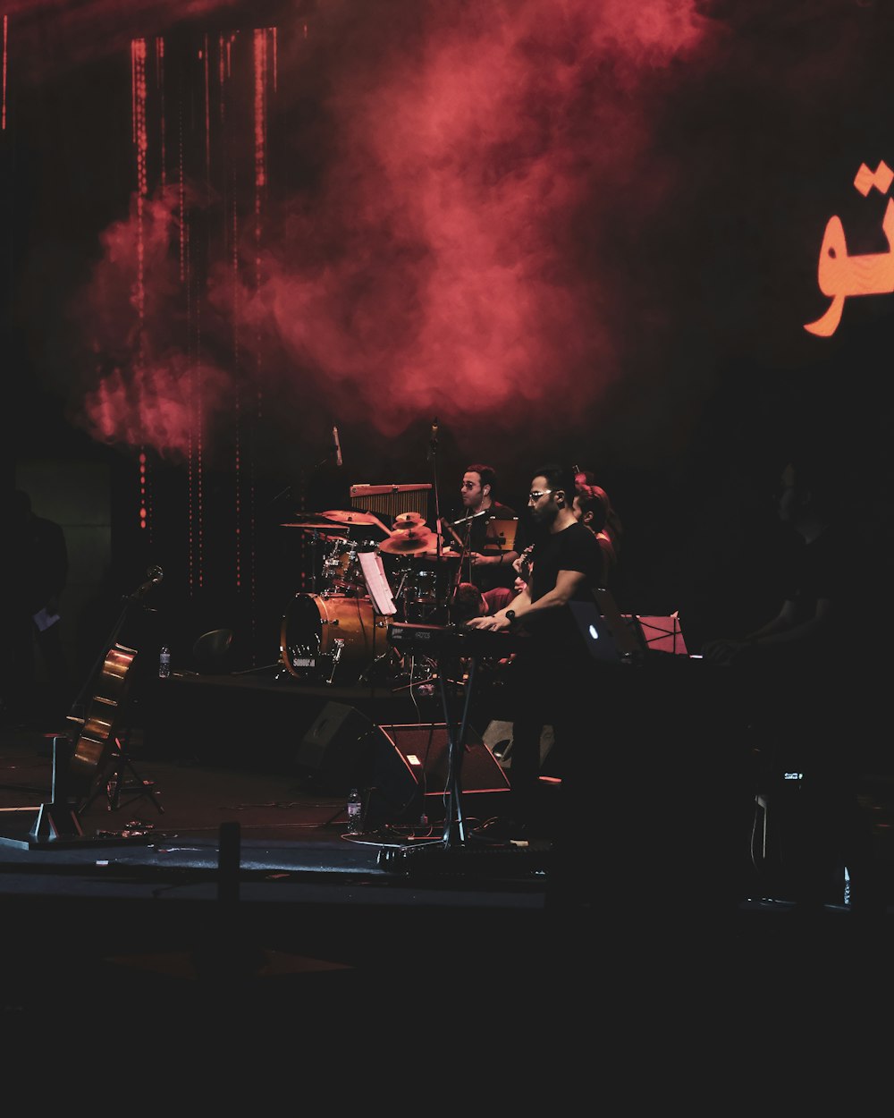 band performing on stage with red lights