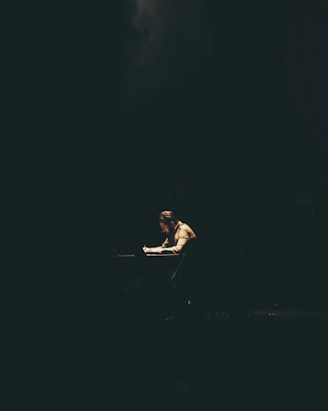 Portrait of a focused copywriter working late in a cozy, dimly lit studio.
