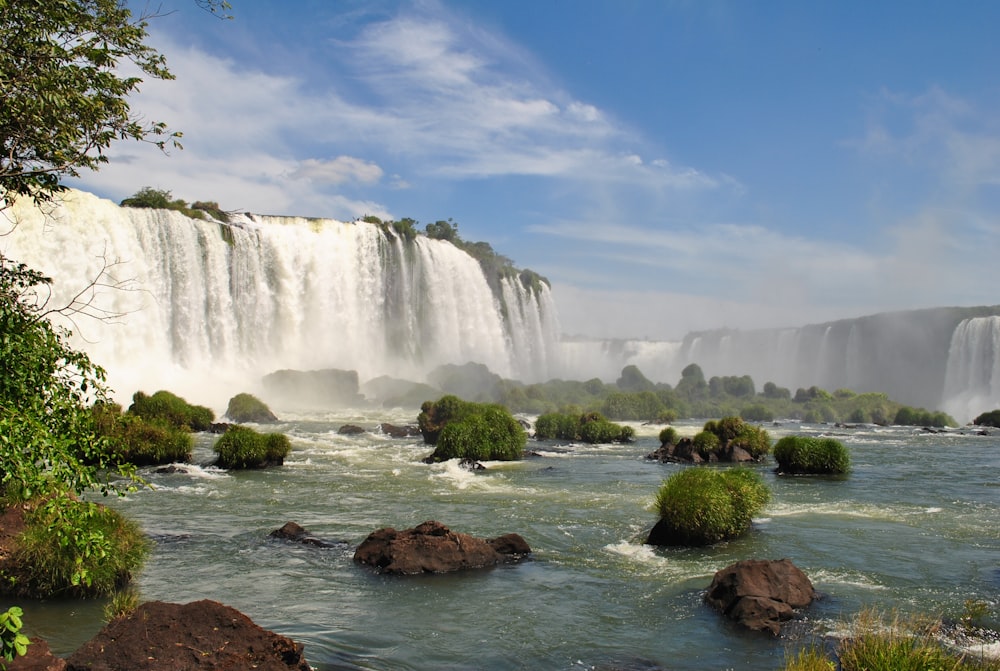 waterfalls near green grass field during daytime