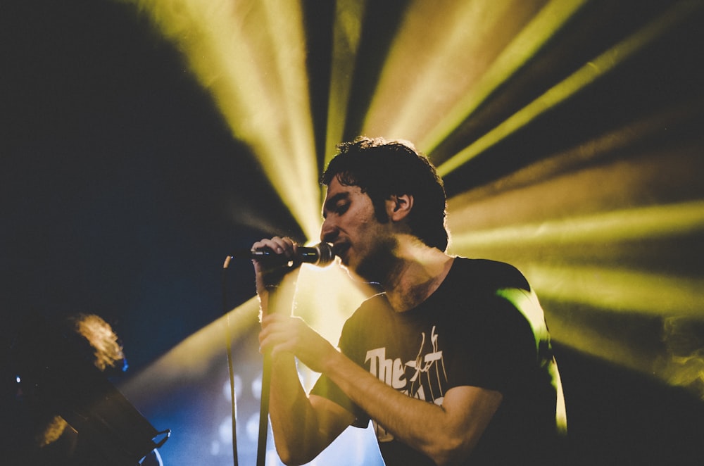 man in black and white crew neck t-shirt singing