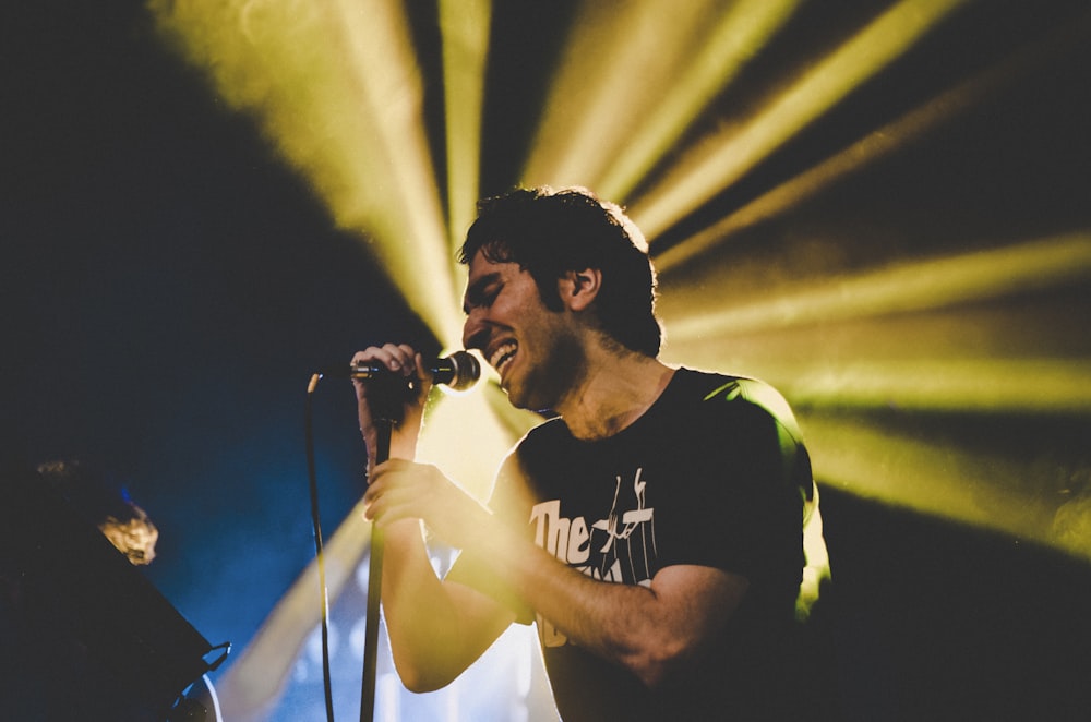 man in black and white crew neck t-shirt singing