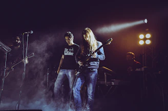 man in black t-shirt playing electric guitar