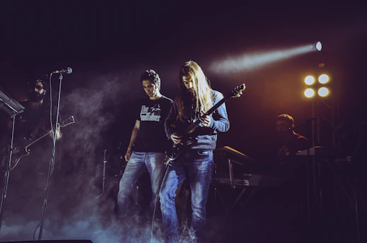 man in black t-shirt playing electric guitar