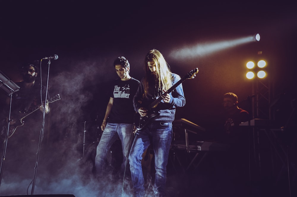 homme en t-shirt noir jouant de la guitare électrique