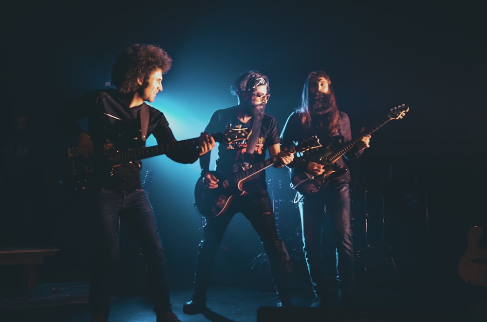 man in black t-shirt playing electric guitar