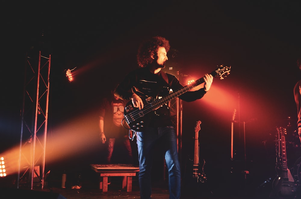 man in black shirt playing guitar