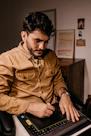 man in brown button up long sleeve shirt holding black smartphone