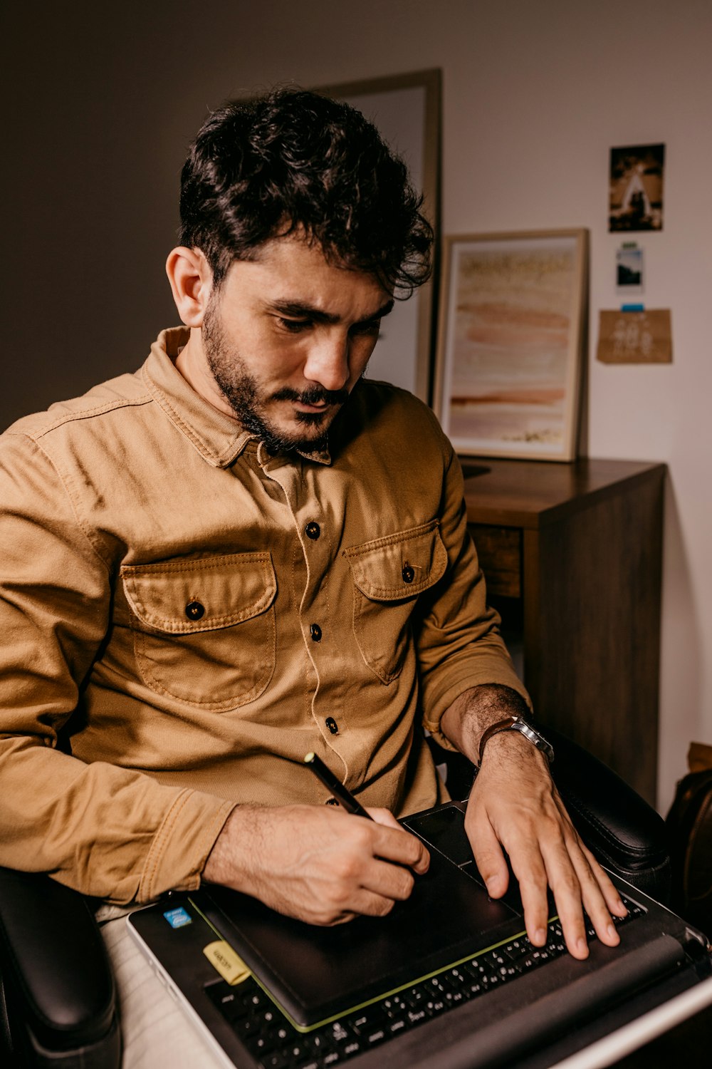Mann in braunem Button-Up-Langarmhemd mit schwarzem Smartphone