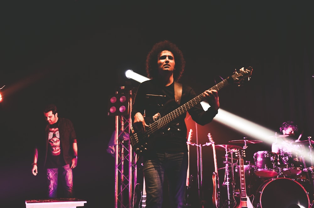 man in black shirt playing guitar on stage