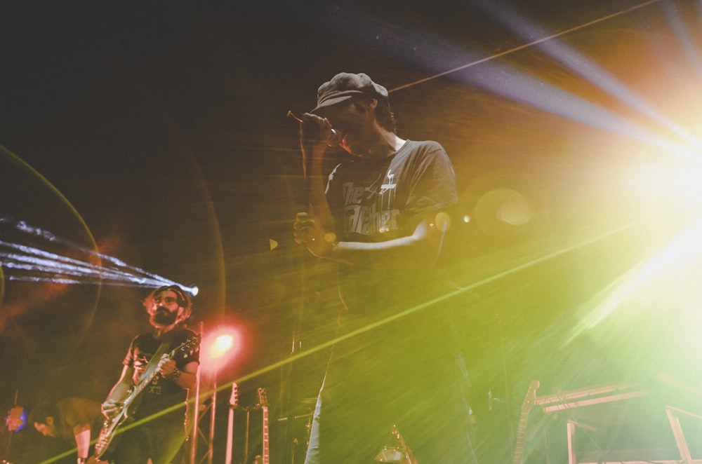 man in black hat and brown shirt playing guitar