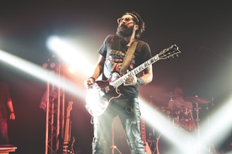 man in black crew neck t-shirt playing electric guitar