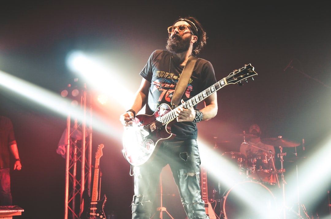 man in black crew neck t-shirt playing electric guitar